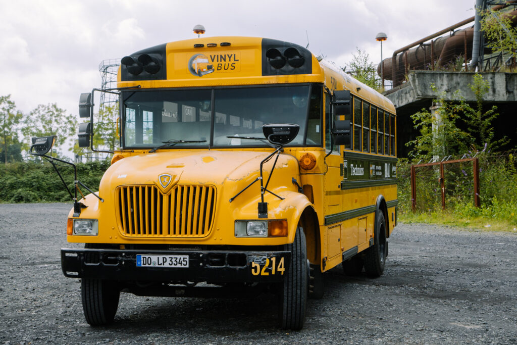 Der gelbe Schulbus, Kennzeichen DO-LP 3345, steht auf einem alten Zechengelände