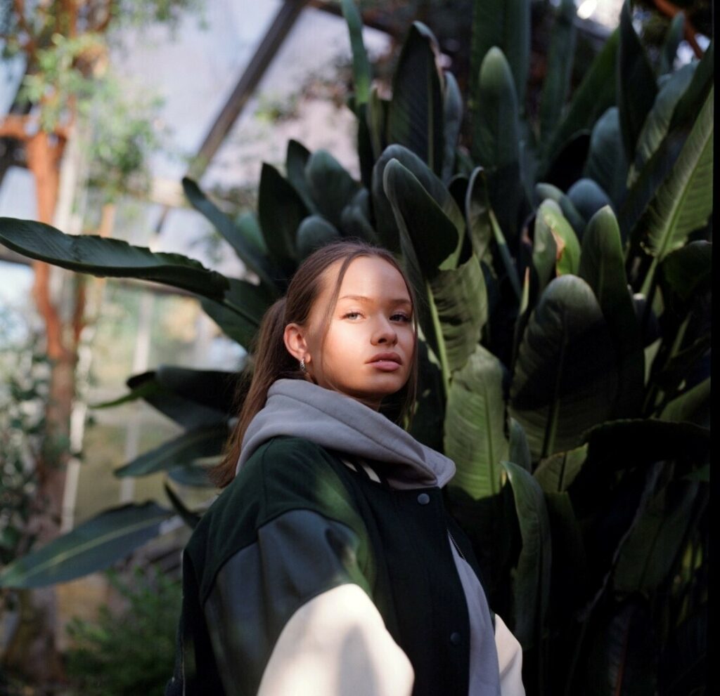 Eine junge Frau steht vor einer Pflanze