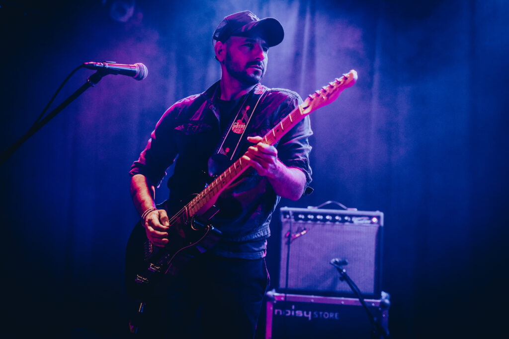 Gale Paridjanian mit Gitarre in blauem Bühnenlicht