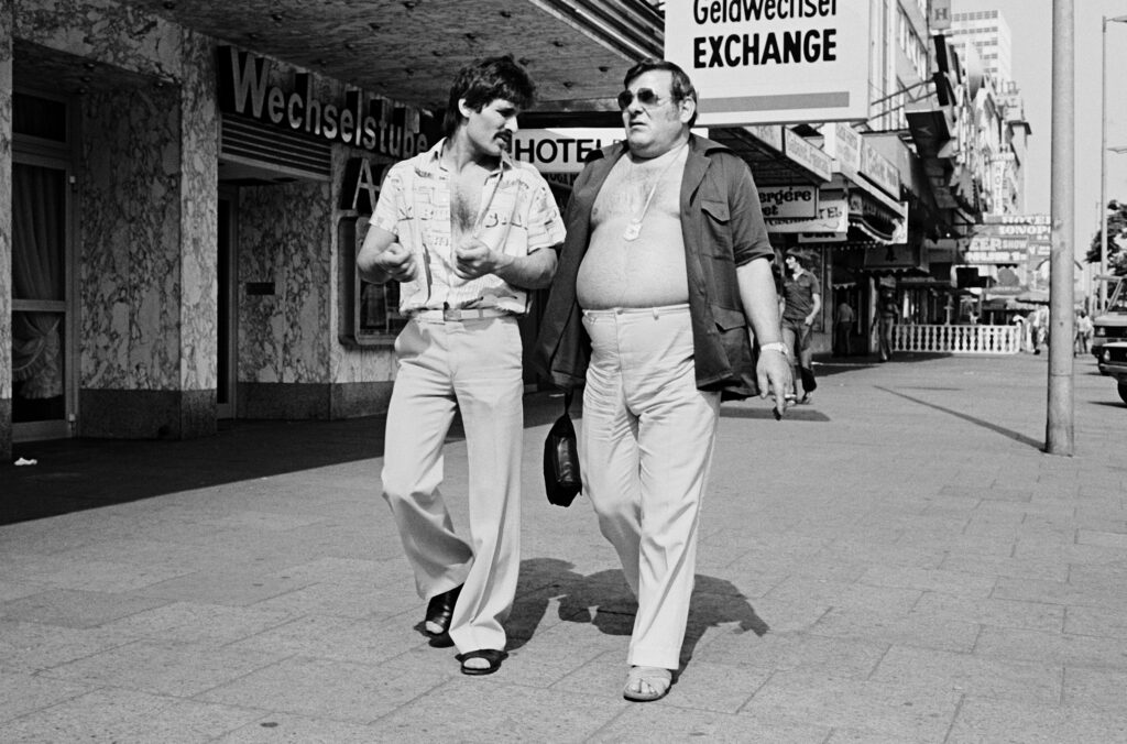 Schwarzweißfoto aus dem 70ern, zwei männer gehen über die Reeperbahn, einer mit nacktem Oberkörper