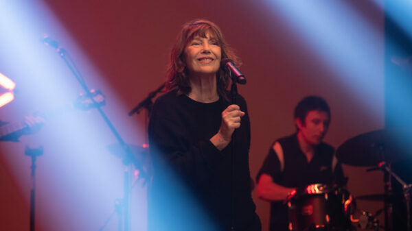 Jane Birkin auf der Bühne vorm Mikrofon, im Hintergrund ein Schlagzeuger