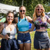 Drei lächelnde Frauen auf dem Campingplatz des Festivals