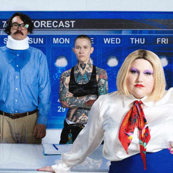 Drei Menschen in einer Art TV-Studio, im Hintergrund eine Wettervorhersage
