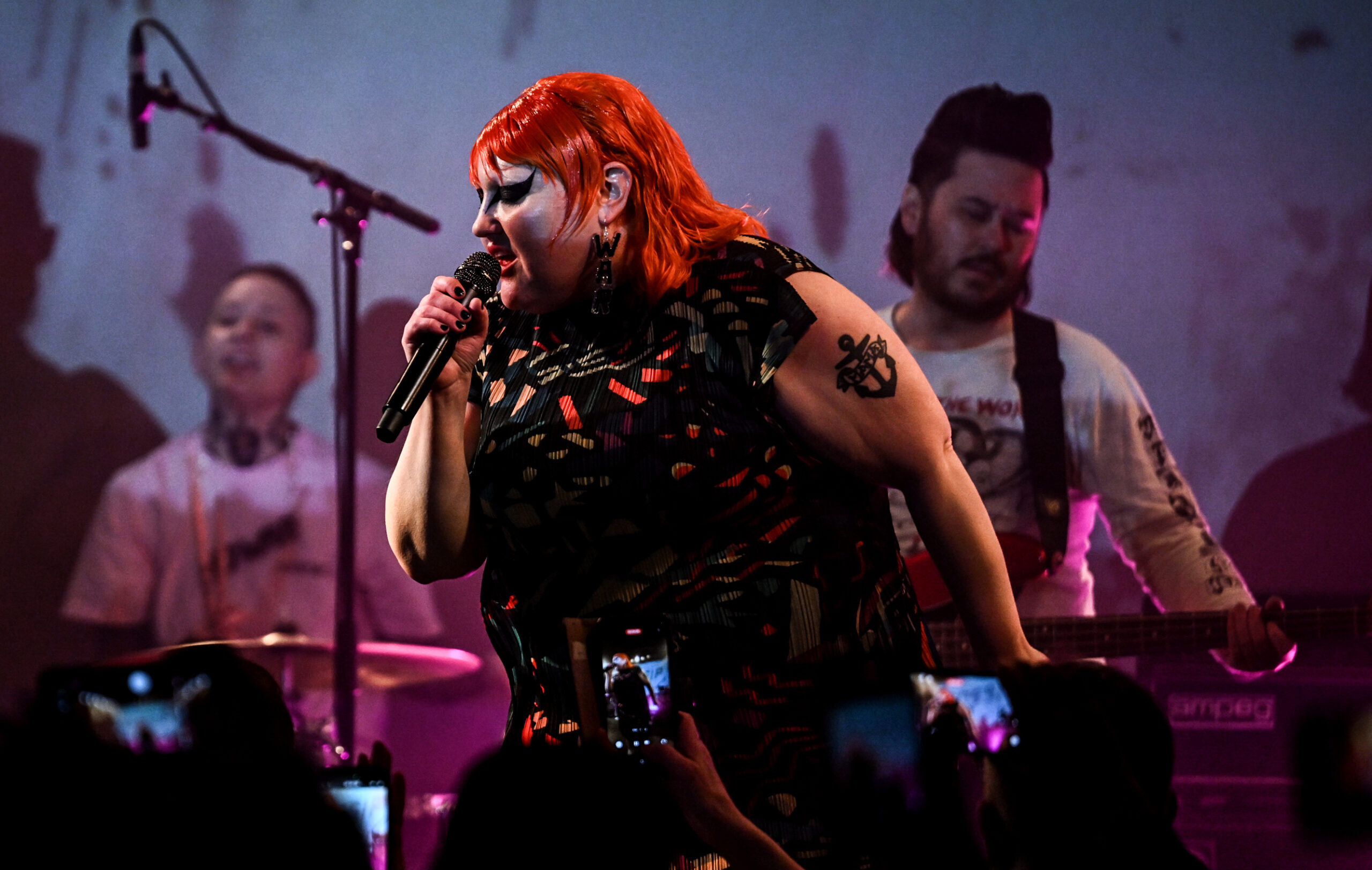 Livesituation, man sieht sie vorne, hinter ihr Bass und Schlagzeug