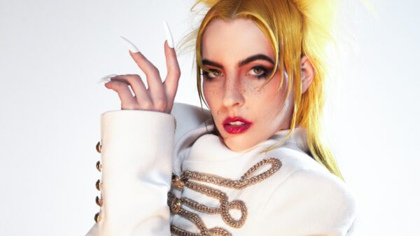 Dorian Electra trägt eine weiße Uniformjacke mit goldenen Verzierungen, die Haare sind blond.