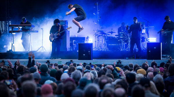 Band auf der Bühne, Publikum davor, Mike Skinner springt gerade von einer Monitorbox