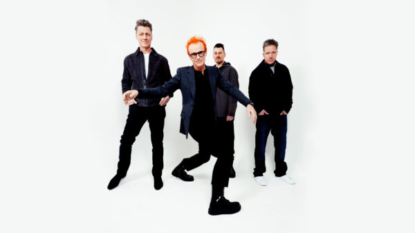 Vier Männer in schwarzer Kleidung vor weißem Hintergrund