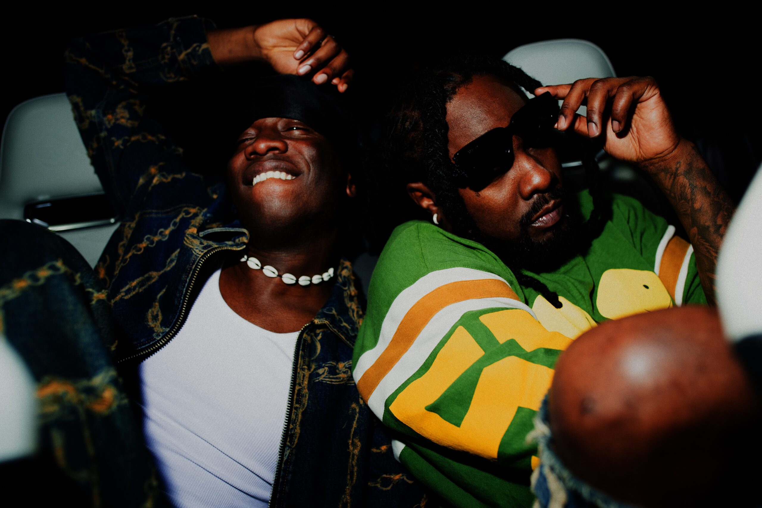 Zwei Männer, die lässig auf einer Autorückbank rumhängen