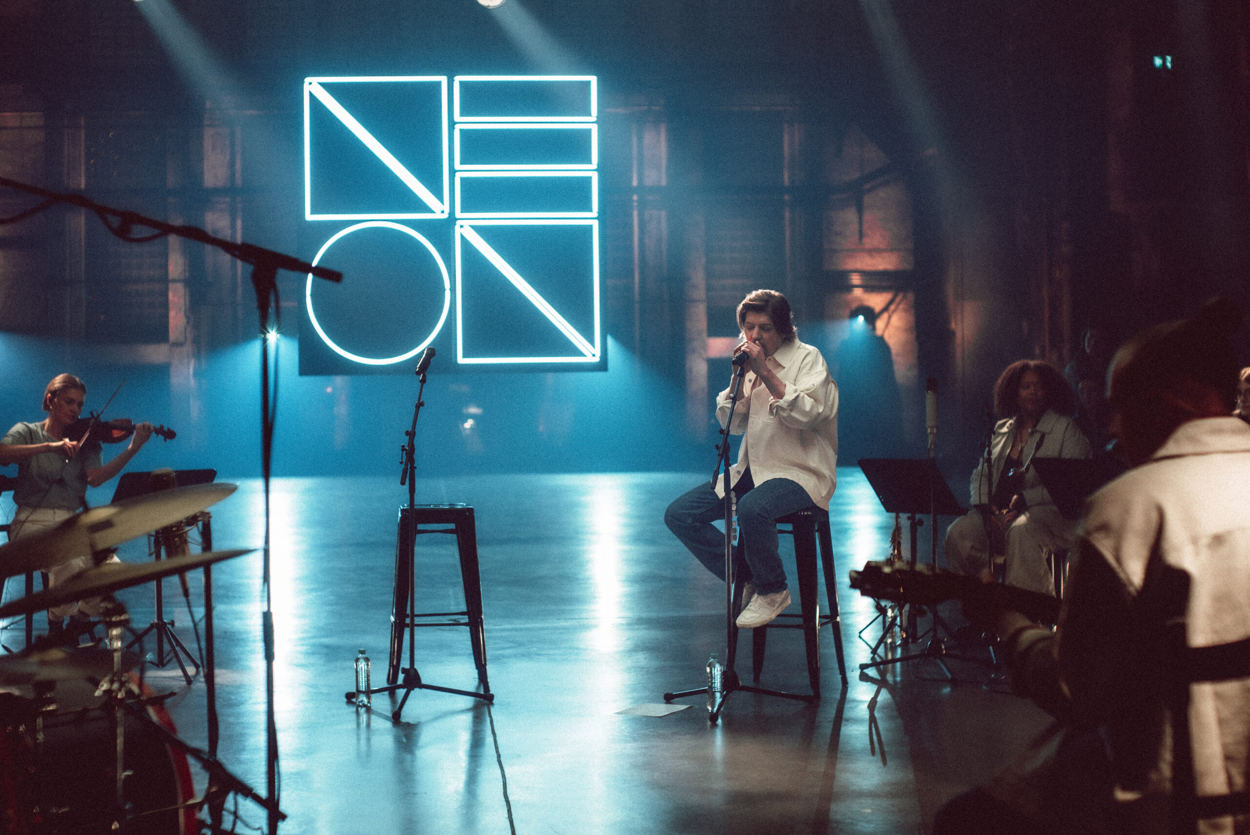 Bühnensituation, Poisel sitzt auf einem Hocker und singt