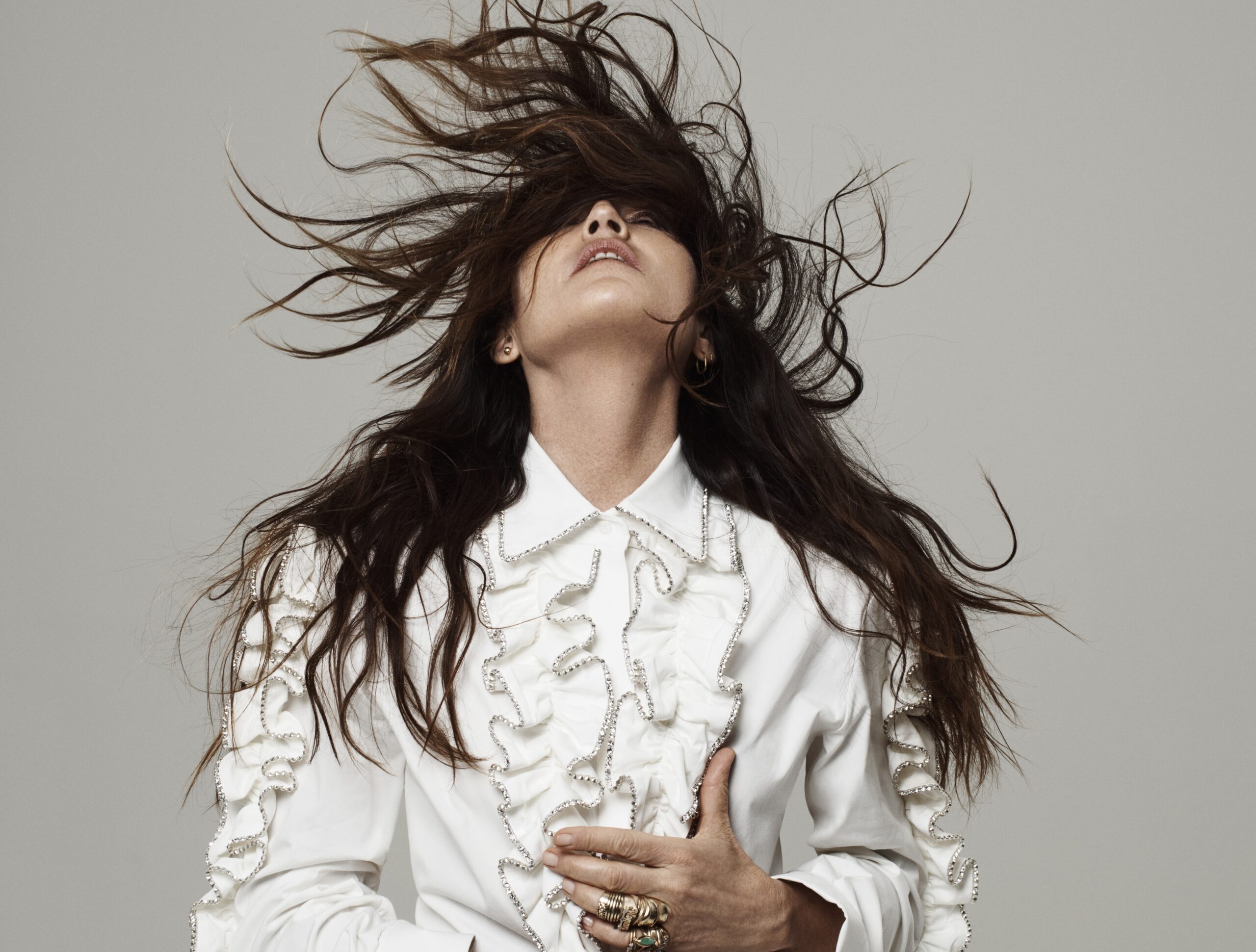 Sie wirft ihre langen Haare nach hinten, die einen Teil ihres Gesichts bedecken