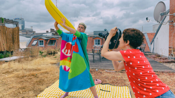 Peaches steht draußen und hält eine riesige Plastikbanane in die Luft, Marie Losier steht vor ihr und filmt sie