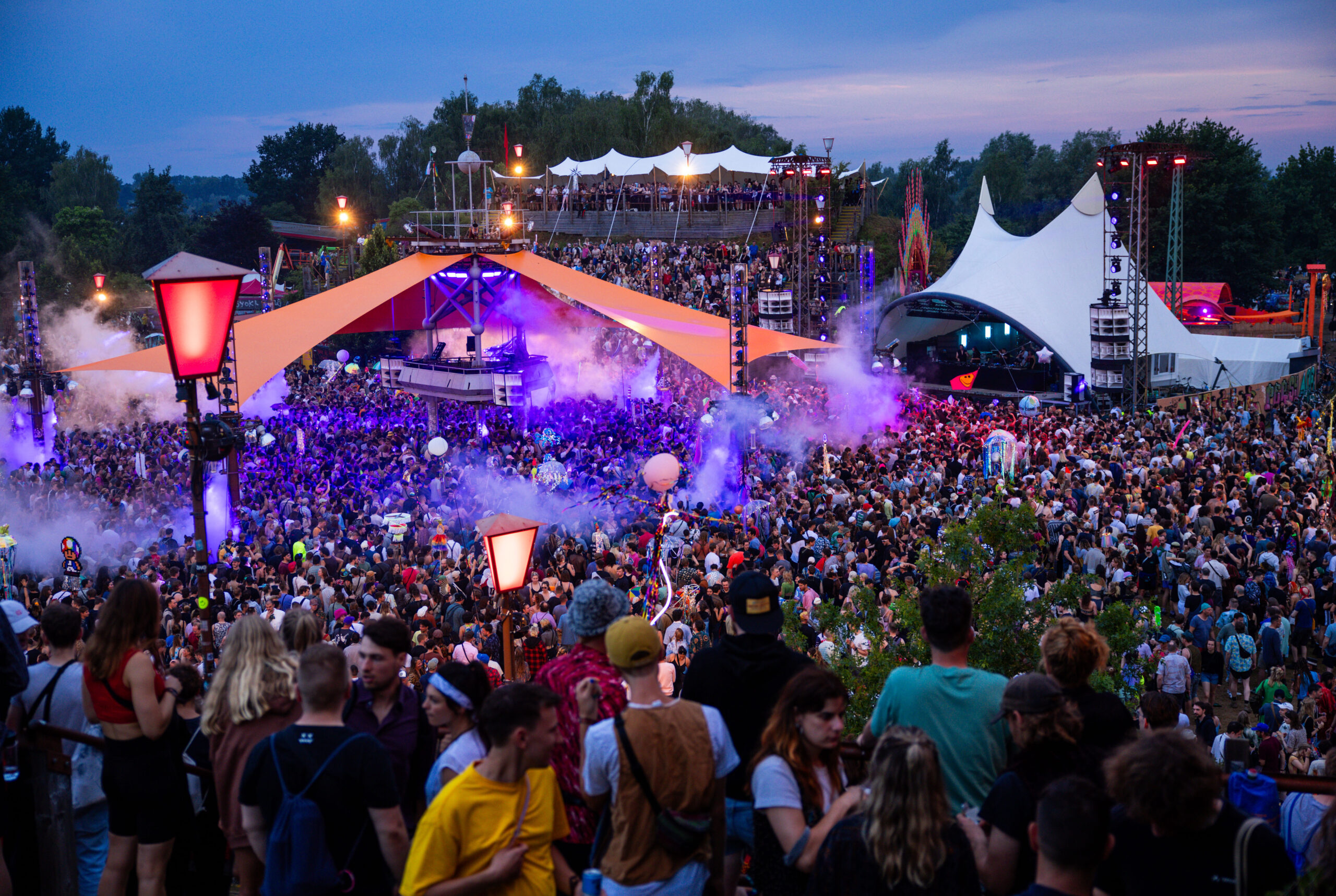 Besucher tanzen vor einer der Bühnen des Fusion-Festival auf dem ehemaligen Militärflugplatz.
