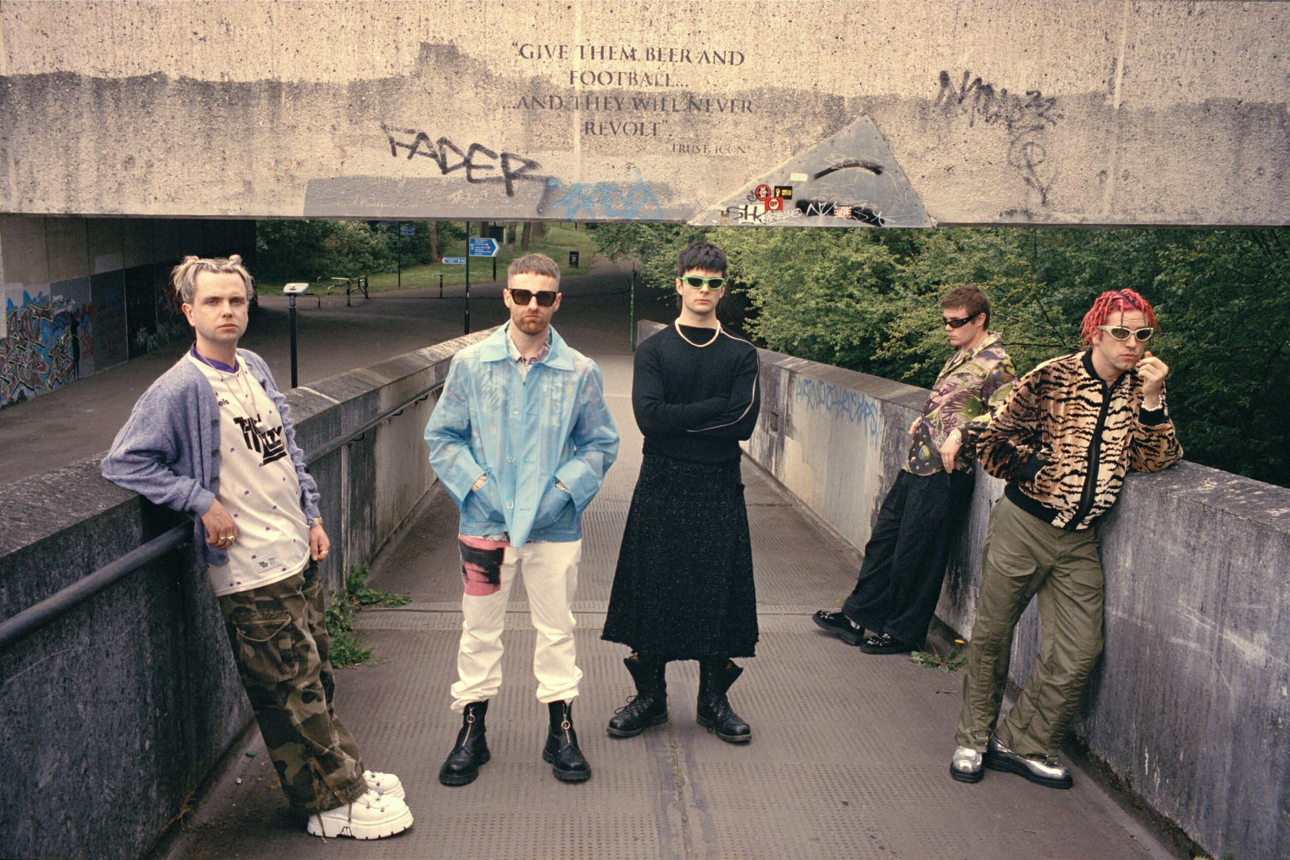 Fünf Männer auf einer großen Rampe. Sie blicken desinteressiert in der Gegend rum beziehungsweise in die Kamera