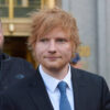 Ein Mann mit roten Haaren und Bart (Ed Sheeran) im Anzug