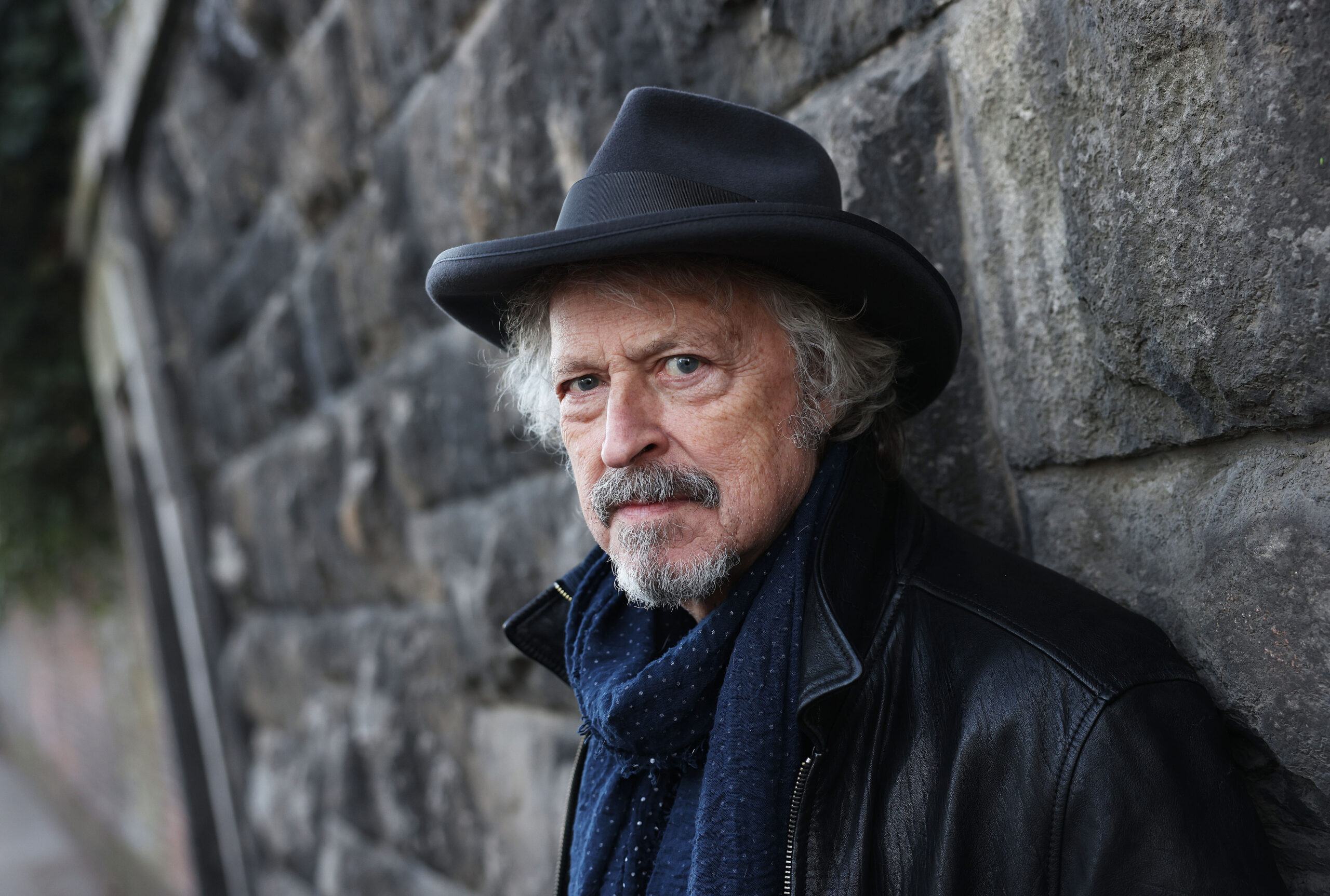 Wolfgang Niedecken lehnt an einer Mauer.