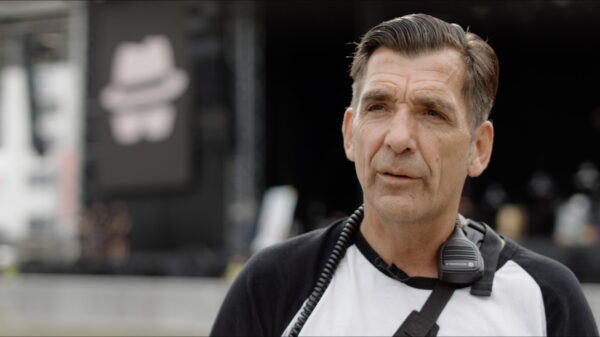 Ein Mann draußen, im Hintergrund eine riesige Konzertbühne