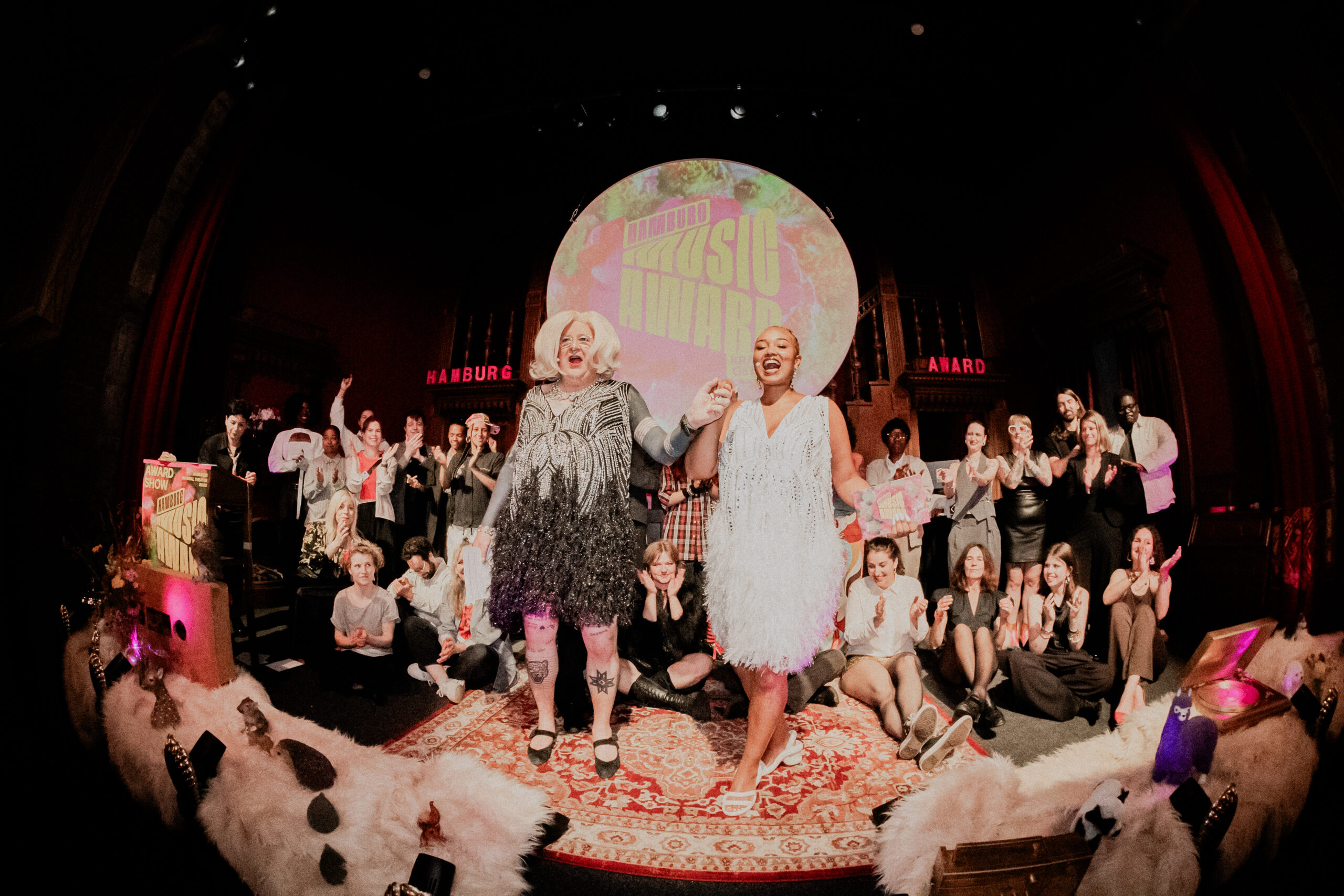 Viele lachende Menschen auf der Bühne