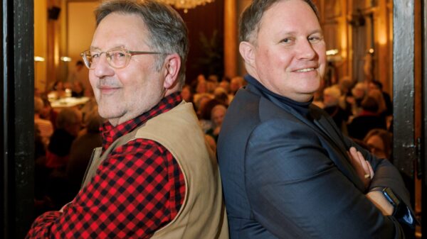 Links Moritz, rechts Brosda, sie stehen Rücken an Rücken und schauen in die Kamera. Im Hintergrund Publikum im Literaturhaus