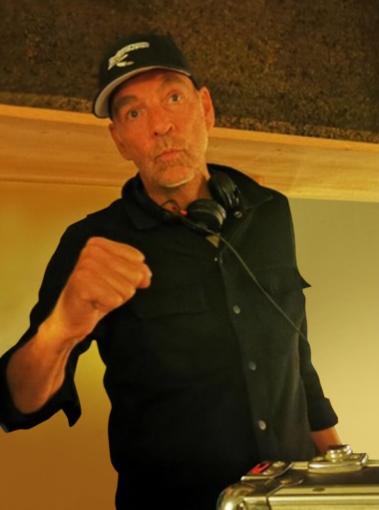 Ein Mann mit Kopfhörern um den Hals, er macht eine Faust