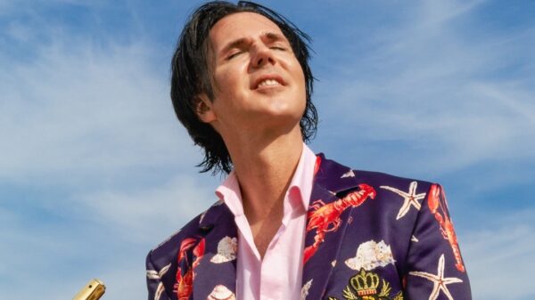 Alexander Marcus, dunkle Haare, er trägt ein bunt gemustertes Jackett.