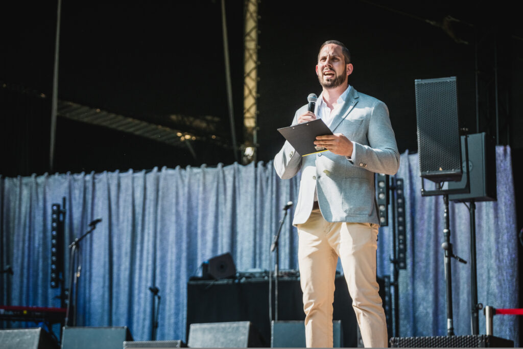 Ben Mitha mit Mikro in der Hand auf der Bühne