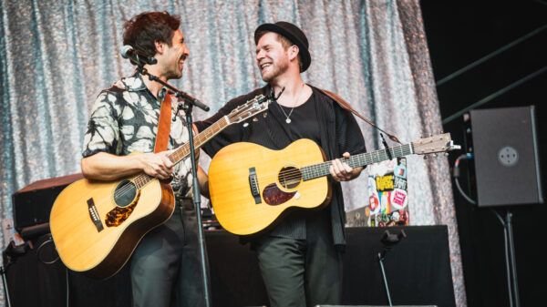 Beide mit Gitarren, sie lachen und umarmen sich