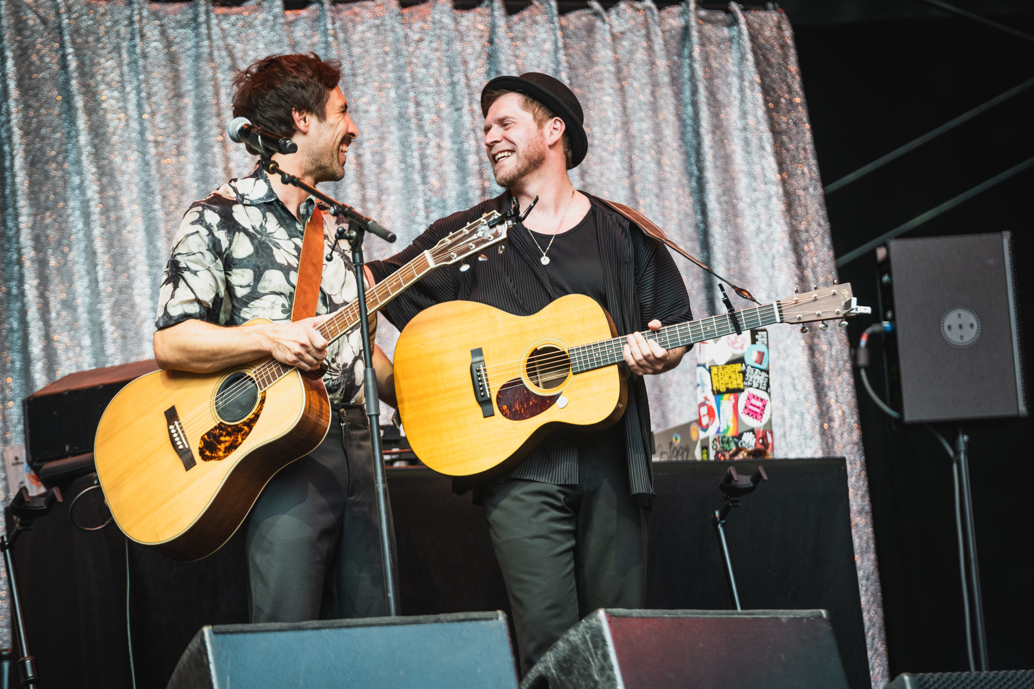 Beide mit Gitarren, sie lachen und umarmen sich
