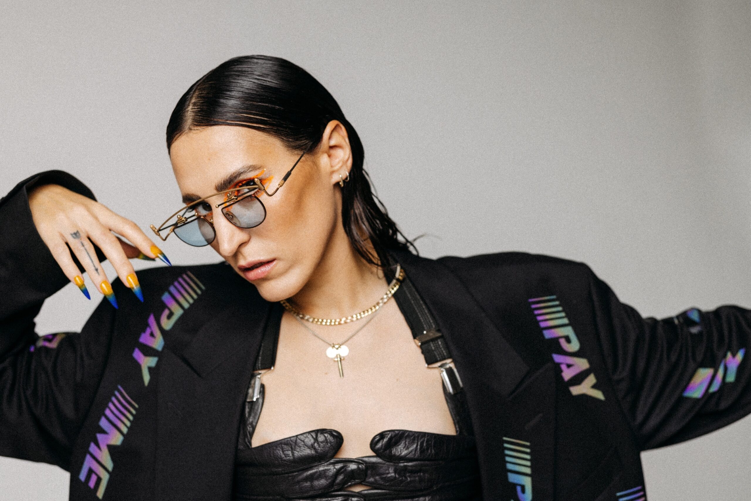Foto der Sängerin, sie trägt eine extravagante Brille und lange, spitze Fingernägel