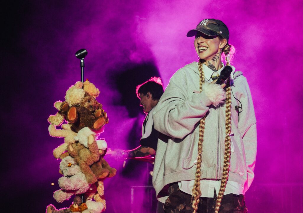 Sie steht lächelnd auf der Bühne, neben ihr ein Mirko-Ständer, um den viele Teddybären gewickelt sind