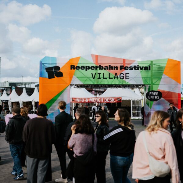 Einfang zum Gelände auf dem Heiligengeistfeld, man kann „Reeperbahn Festival Village, free entry“ lesen, davor stehen Menschen