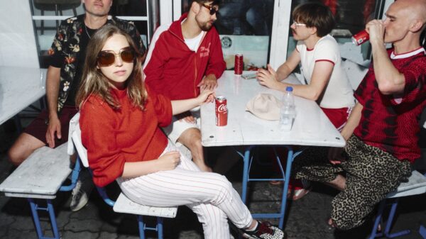 Fünf Menschen sitzen um einen Tisch herum auf Bierbänken