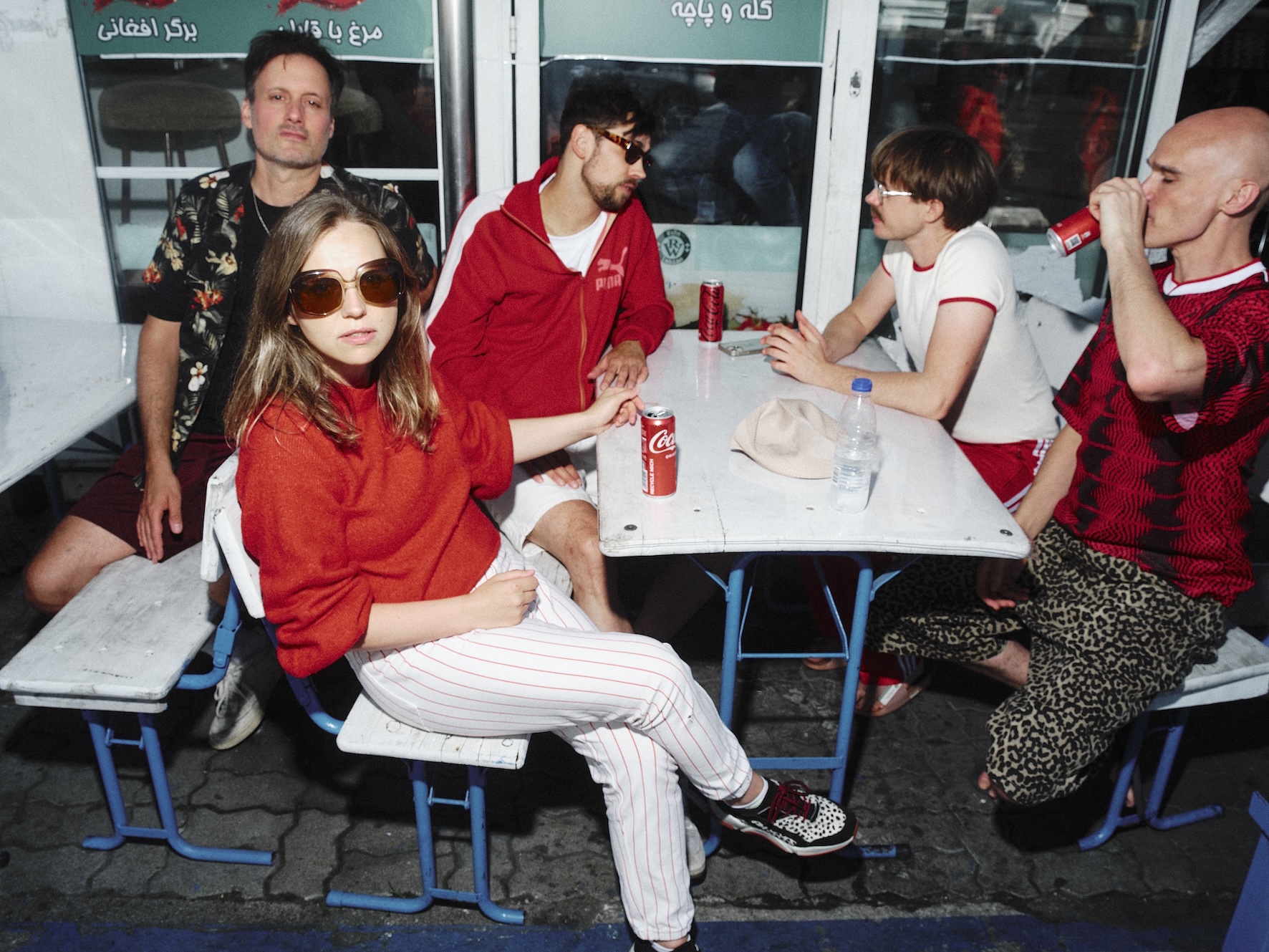 Fünf Menschen sitzen um einen Tisch herum auf Bierbänken