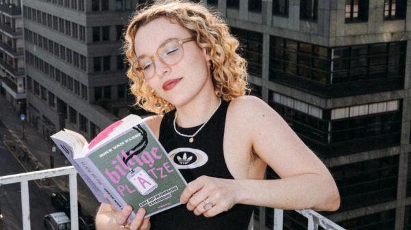 Sie steht auf einem Balkon, hat das Buch in der Hand und liest