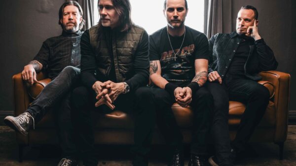 Die vier Mitglieder von Alter Bridge sitzen nebeneinander auf einem Sofa.