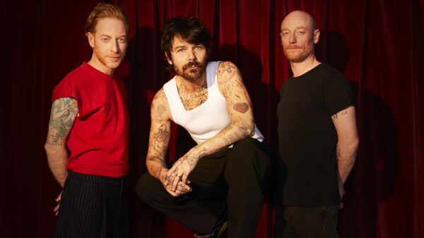 Drei Männer, alle schauen in die Kamera