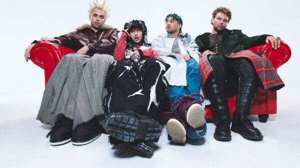 Die vier Bandmitglieder von 5 Seconds Of Summer sitzen auf einem roten Sofa.