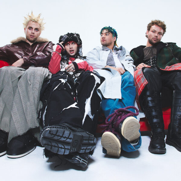 Die vier Bandmitglieder von 5 Seconds Of Summer sitzen auf einem roten Sofa.