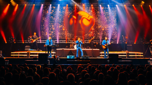 Bunte Scheinwerfer erleuchten eine Bühne während eines Konzerts.