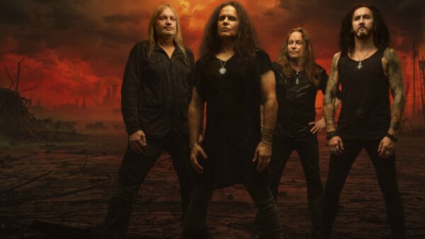 Die vier Bandmitglieder von „Kreator“ vor einem roten, apokalyptischen Hintergrund