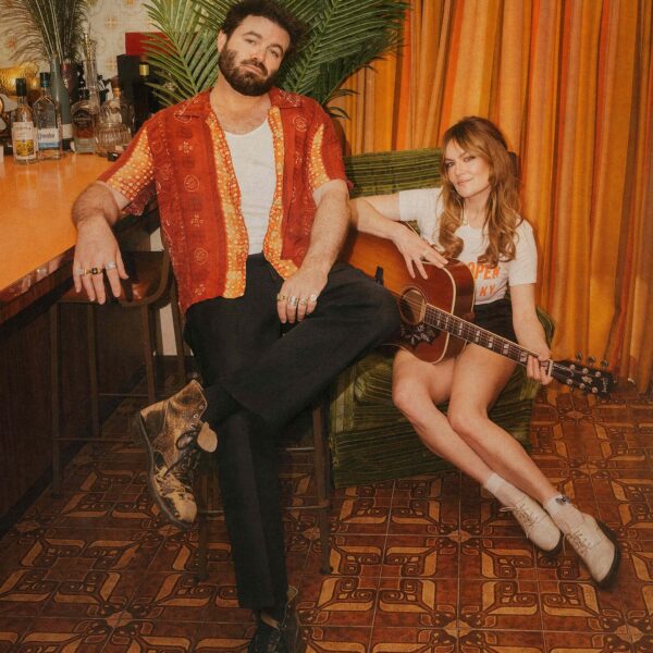Angus & Julia Stone sitzen auf einem retro Sofa.